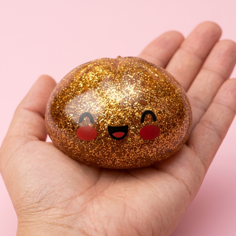 Dumpling Squishy Glitter Or Unique Trésor tenu en main, taille réelle