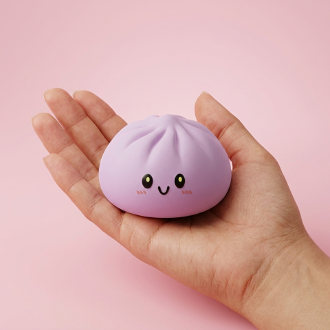 Dumpling Squishy Gris Magenta tenu en main, taille réelle