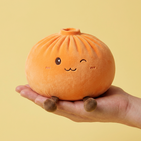 Giant Dumpling Squishy Orange tenu en main, taille réelle
