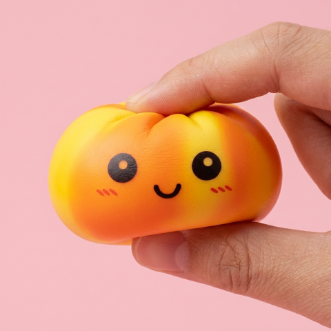 Squishy Dumpling Tie Dye Orange pressé dans la main, matière squishy
