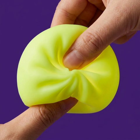 Veilleuse Dumpling Squishy Jaune Soleil pressé dans la main, matière squishy